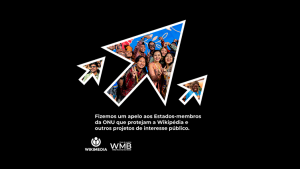 A imagem apresenta um grande cursor de mouse branco com contornos pretos, que está centralizado e aponta para uma foto de um grupo de pessoas. O fundo da imagem é preto, criando um contraste acentuado com o cursor branco. Na parte inferior da imagem, há um texto em português que faz um apelo aos Estados-membros da ONU para proteger a Wikipédia e outros projetos de interesse público. Além disso, os logos da Wikimedia e do Wiki Movimento Brasil (WMB) estão posicionados no canto inferior esquerdo da imagem.